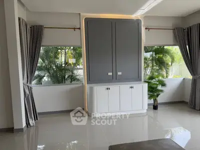 Spacious modern living room with large windows and lush garden view, perfect for relaxation and entertaining.