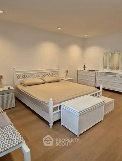 Spacious bedroom with elegant white furniture and cozy ambiance