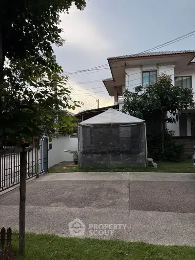 Charming suburban house with spacious driveway and lush greenery, perfect for family living.