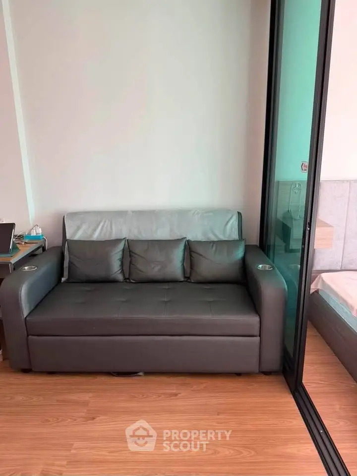 Modern living room with sleek sofa and sliding glass door in stylish apartment.