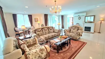 Luxurious living room with elegant chandelier and plush sofas in a spacious, well-lit area.