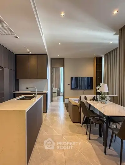 Modern open-layout kitchen and living room with sleek design and elegant furnishings.