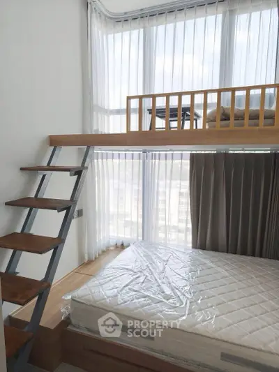 Modern loft bedroom with large windows and stylish wooden ladder