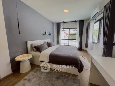 Modern bedroom with stylish decor and large windows offering natural light.