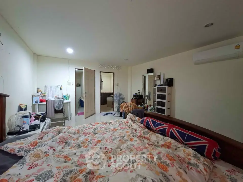 Cozy bedroom with floral bedding and air conditioning in modern apartment