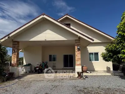 Charming single-story house with spacious driveway and lush greenery, perfect for serene living.
