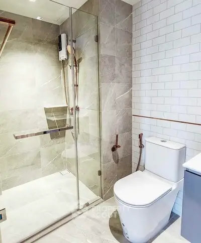 Modern bathroom with glass shower and sleek toilet design.