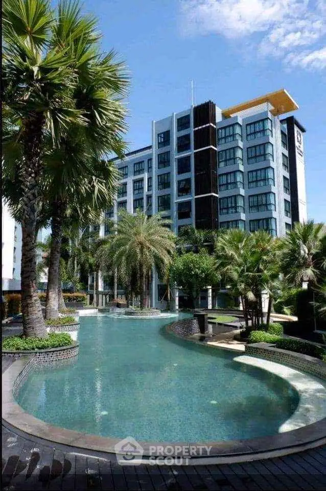Luxurious condominium with stunning pool and lush tropical landscaping.