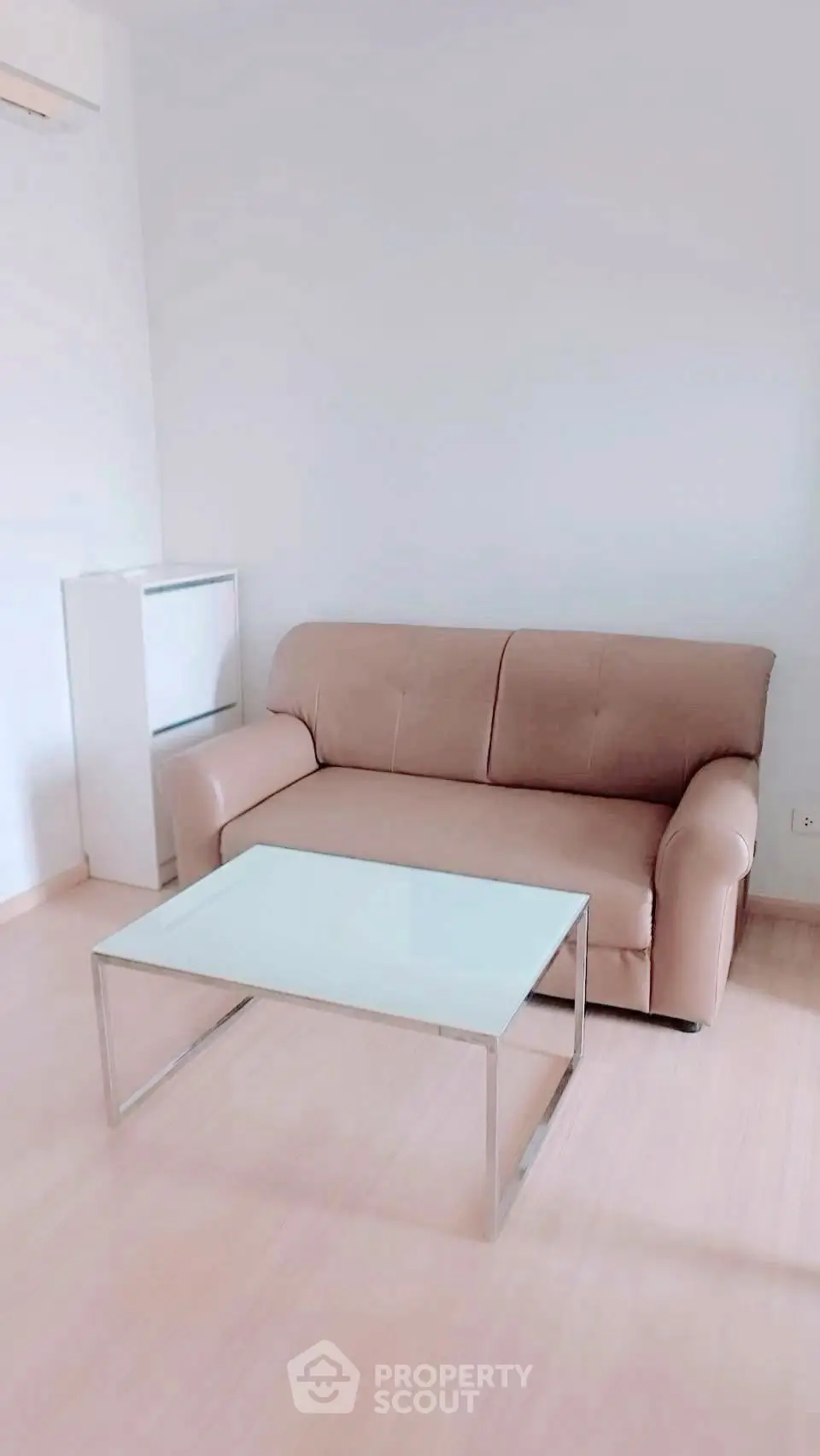 Minimalist living room with beige sofa and modern glass coffee table