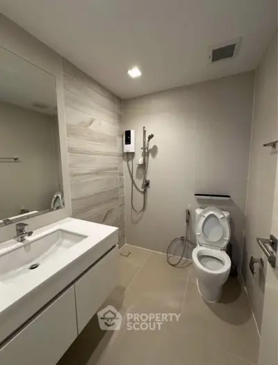 Modern bathroom with sleek fixtures and neutral tones, featuring a spacious shower and elegant vanity.