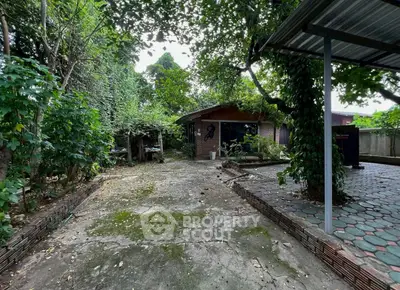 Charming garden view with lush greenery and rustic brick house