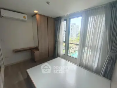 Bright bedroom with large windows and modern furnishings in a stylish apartment.