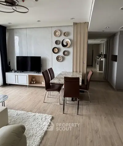 Modern living room with stylish decor and open layout, featuring a dining area and sleek flooring.