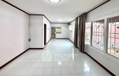 Spacious and bright living room with large windows and tiled flooring in modern home.