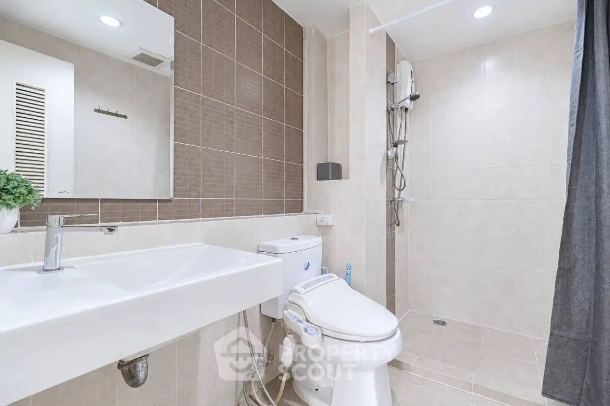 Modern bathroom with sleek fixtures and walk-in shower in contemporary apartment.