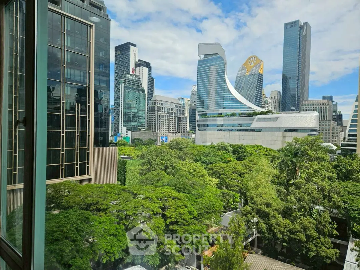 Stunning cityscape view from a high-rise apartment window, showcasing modern architecture and lush greenery.