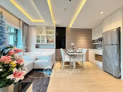 Modern open-layout living room and kitchen with elegant decor and natural light.