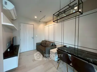 Modern living room with sleek furniture and stylish lighting in a compact apartment.