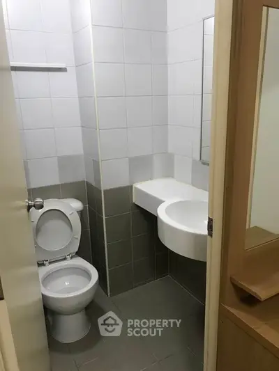 Compact bathroom with modern fixtures and neutral tiles