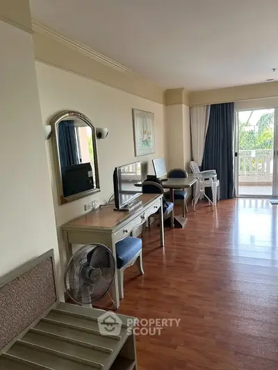 Spacious living room with wooden flooring and balcony view