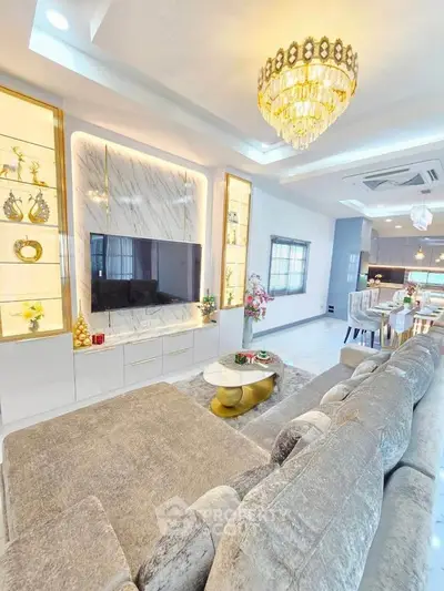 Luxurious living room with elegant chandelier and modern open kitchen layout