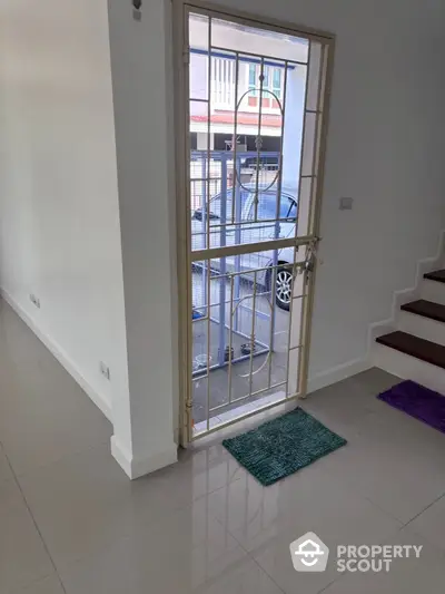 Modern home entrance with secure metal door and polished tile flooring