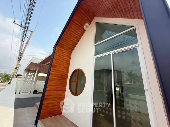 Modern architectural exterior with unique wooden accents and large windows.