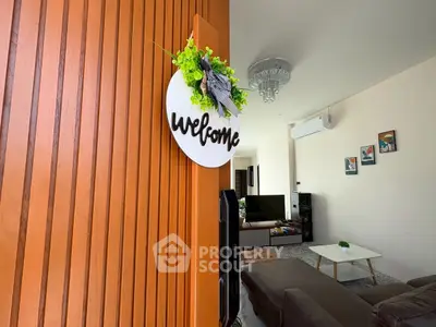 Inviting living room with modern decor and welcoming sign, perfect for relaxation and entertainment.