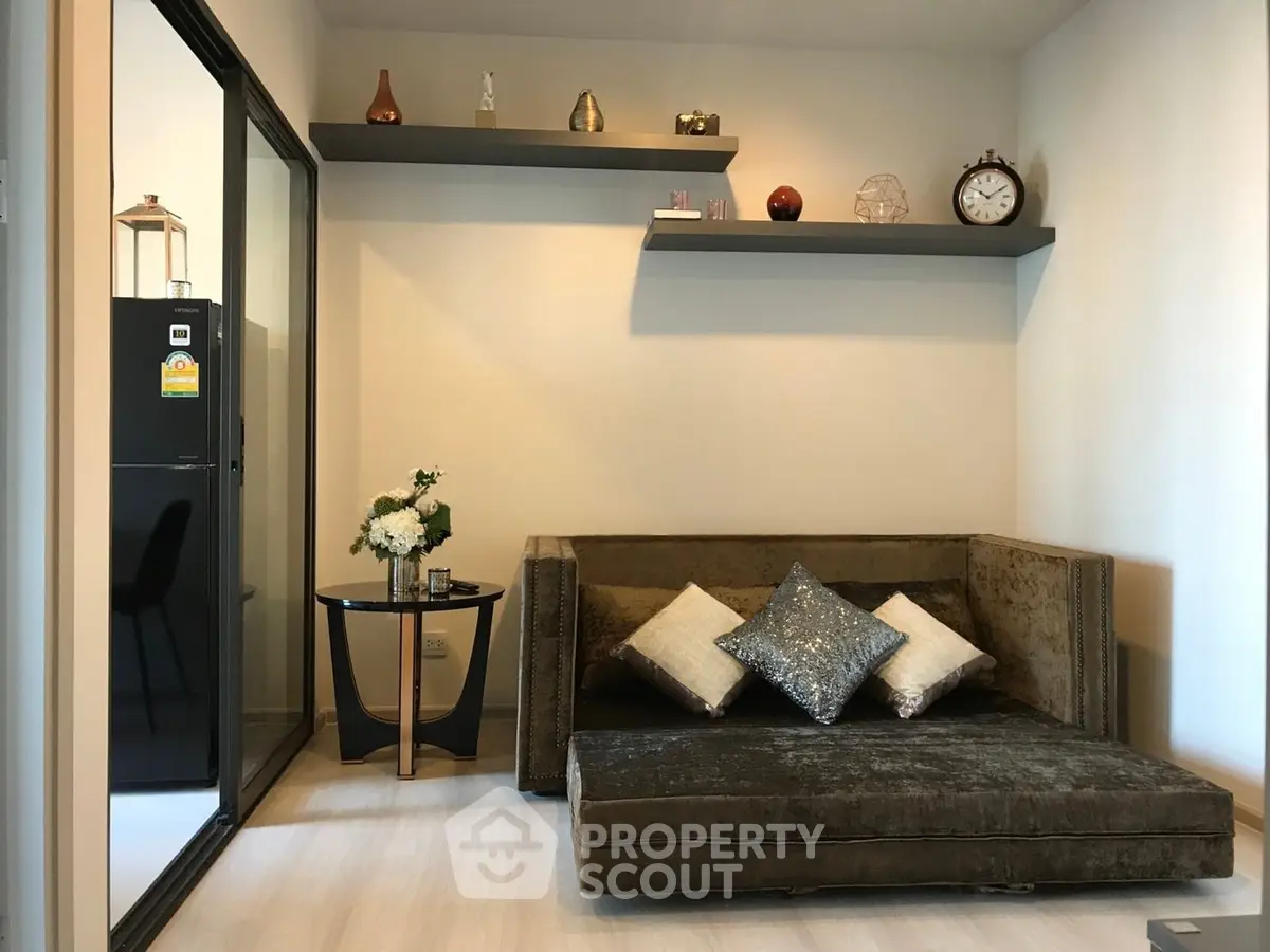 Modern living room with plush sofa and decorative shelves in a cozy apartment setting.