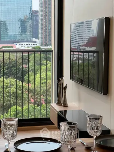 Modern dining area with city view from balcony, featuring elegant table setting and wall-mounted TV.