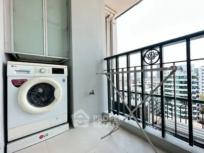 Modern balcony with city view, washing machine, and drying rack in urban apartment.