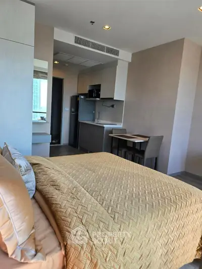 Modern studio apartment with cozy bedroom and compact kitchen area, ideal for urban living.