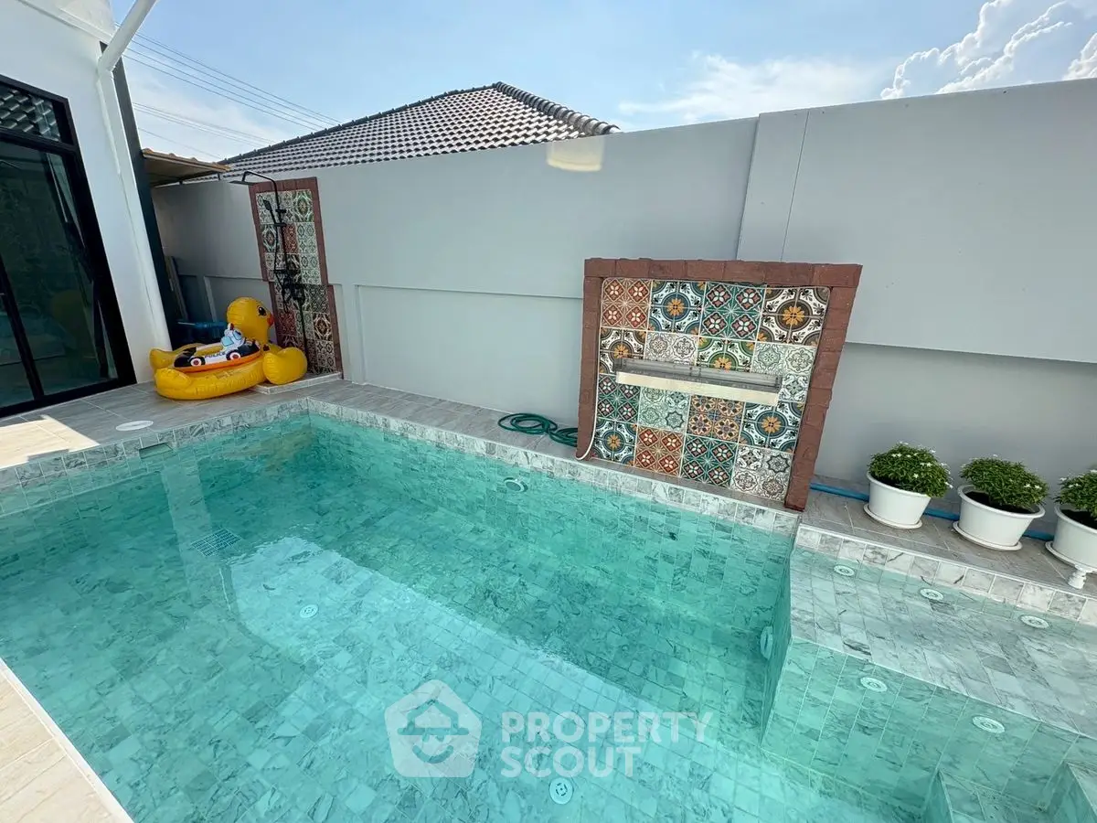 Stunning private pool with decorative tiles and poolside plants, perfect for relaxation and leisure.