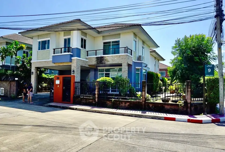 Stunning two-story modern house with lush garden and spacious driveway in a serene neighborhood.