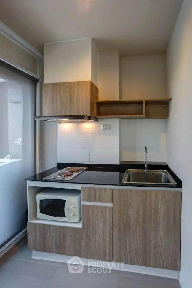Modern compact kitchen with sleek wooden cabinets and built-in appliances