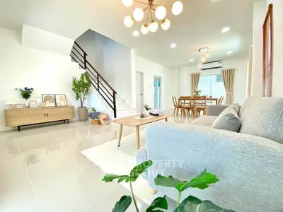 Spacious modern living room with elegant decor and open dining area, perfect for family gatherings.
