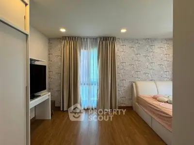 Charming bedroom with stylish wallpaper and cozy bed, featuring a sleek TV setup and elegant curtains.