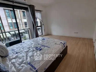 Spacious bedroom with large windows and modern design in a stylish apartment.