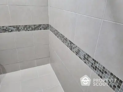 Modern bathroom with stylish tile design and elegant mosaic accents.