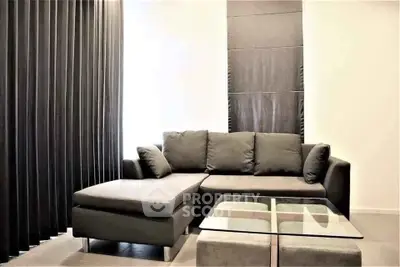 Modern living room with sleek black sofa and glass coffee table, perfect for stylish urban living.
