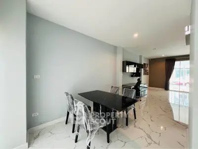 Modern living room with sleek black dining set and marble flooring