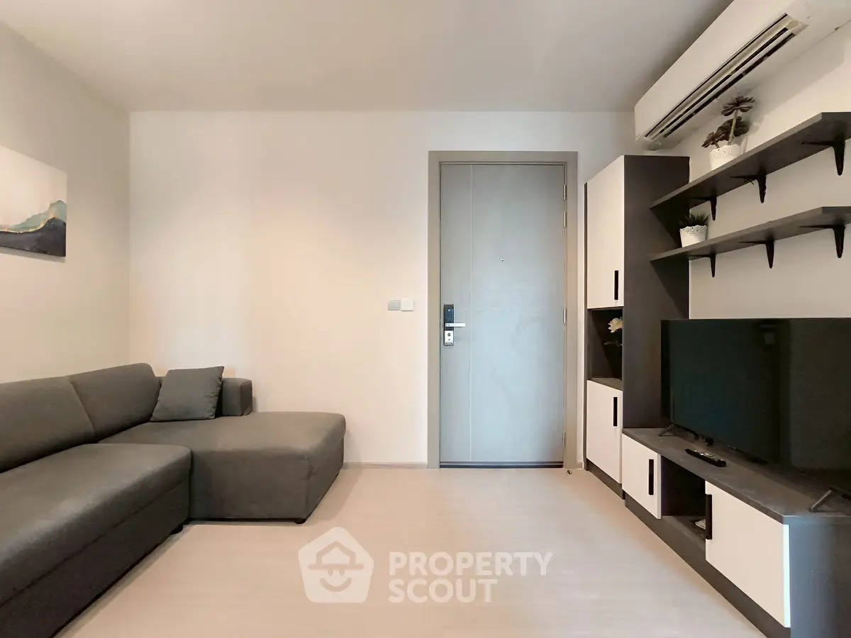 Modern living room with sleek furniture and minimalist design, featuring a comfortable sofa and entertainment unit.