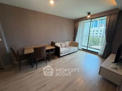 Spacious living room with modern decor and balcony view in a stylish apartment.
