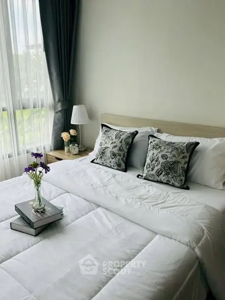 Cozy bedroom with elegant decor and natural light, featuring plush bedding and stylish accents.