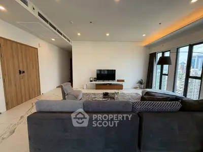 Spacious modern living room with city view, featuring sleek furniture and large windows.