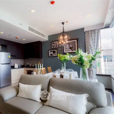 Modern living room with elegant decor and open kitchen layout in a high-rise apartment.