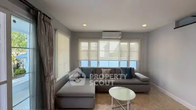 Spacious living room with modern gray sectional sofa and large windows