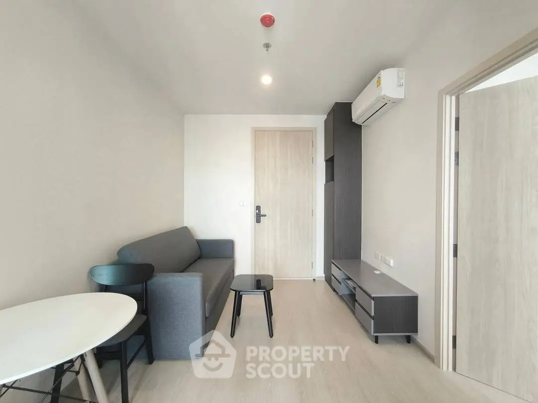 Modern living room with sleek furniture and air conditioning in a minimalist apartment.