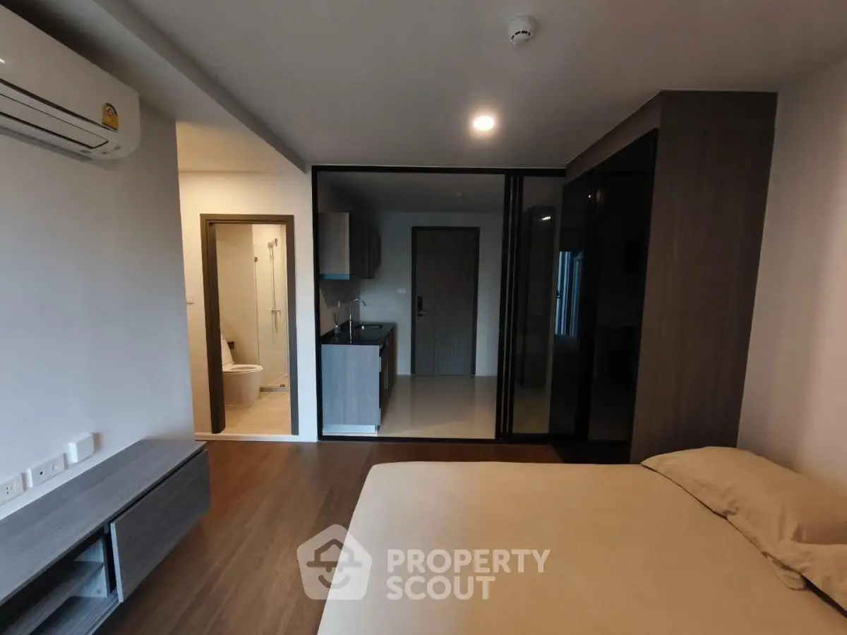 Modern studio apartment with open layout, featuring a cozy bedroom, compact kitchen, and sleek bathroom.