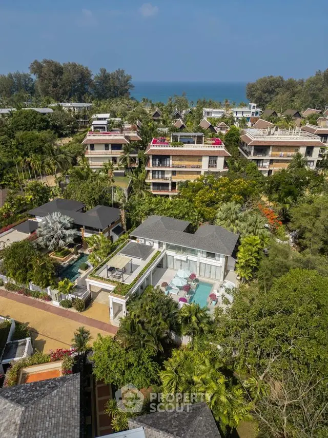 Luxurious beachfront villas with lush gardens and ocean views in a tropical paradise setting.